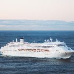 Huge white cruise ship in the middle of the deep blue ocean