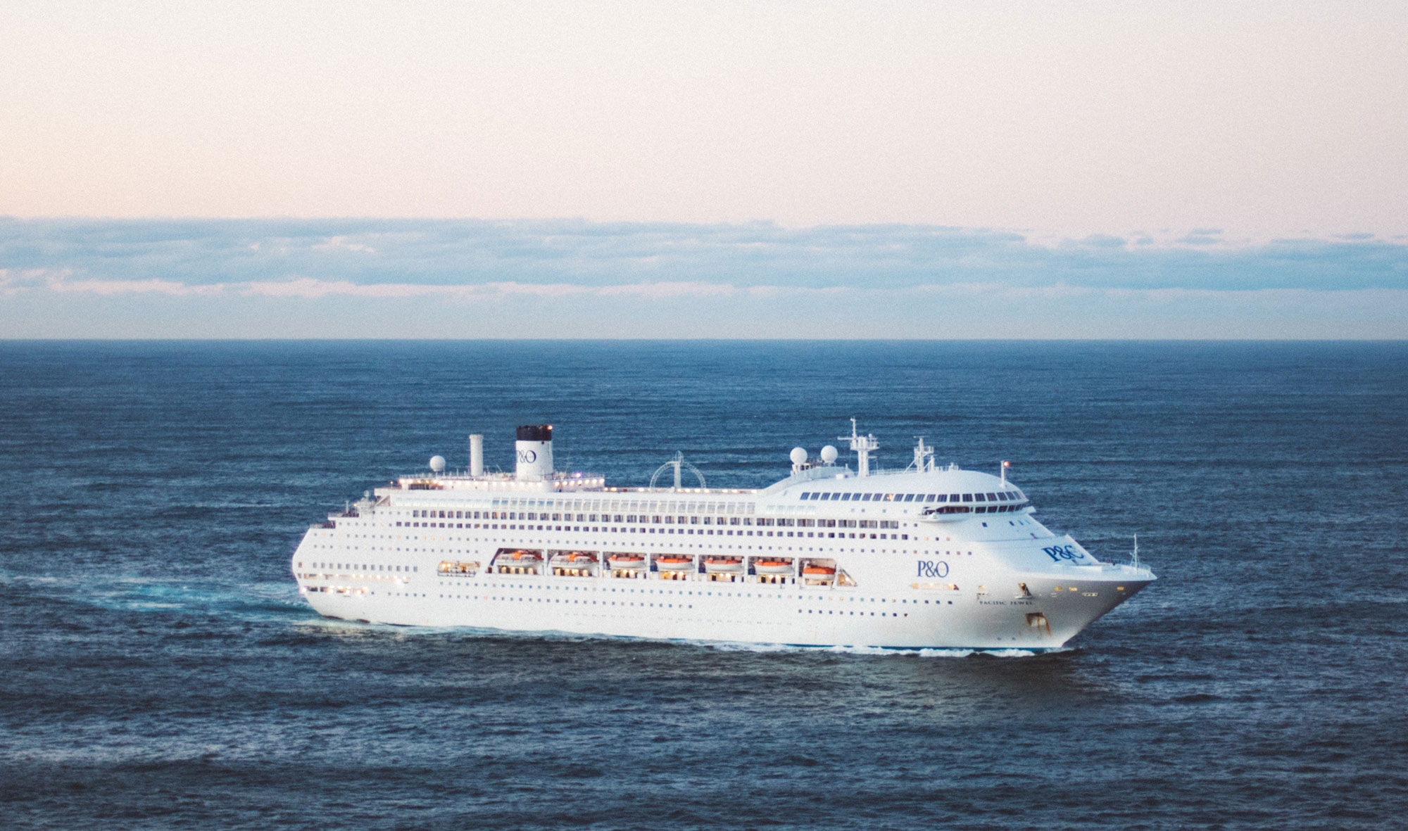 Huge white cruise ship in the middle of the deep blue ocean